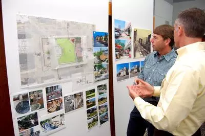 People discussing displayed work and drawings