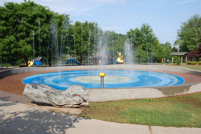 Splash pad with play structure in background