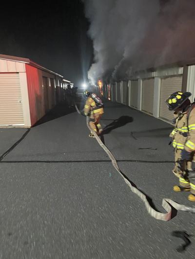 Firefighters responding to a fire using a hose