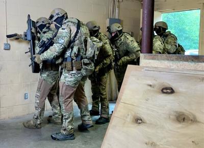 SWAT team members training a stacked formation